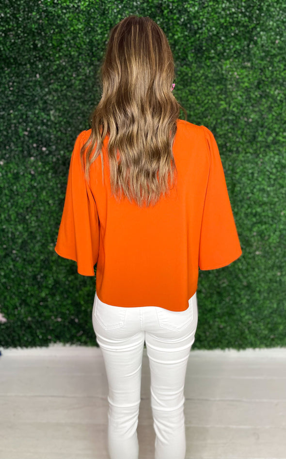back of orange top with statement sleeves
