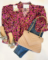 flatly of pink floral top with neutral bag and denim jeans 