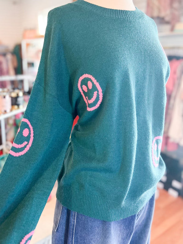 pink smiley faces on teal sweater