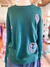 teal sweater with pink smiley faces