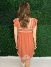 back of burnt orange dress with embroidery detail 